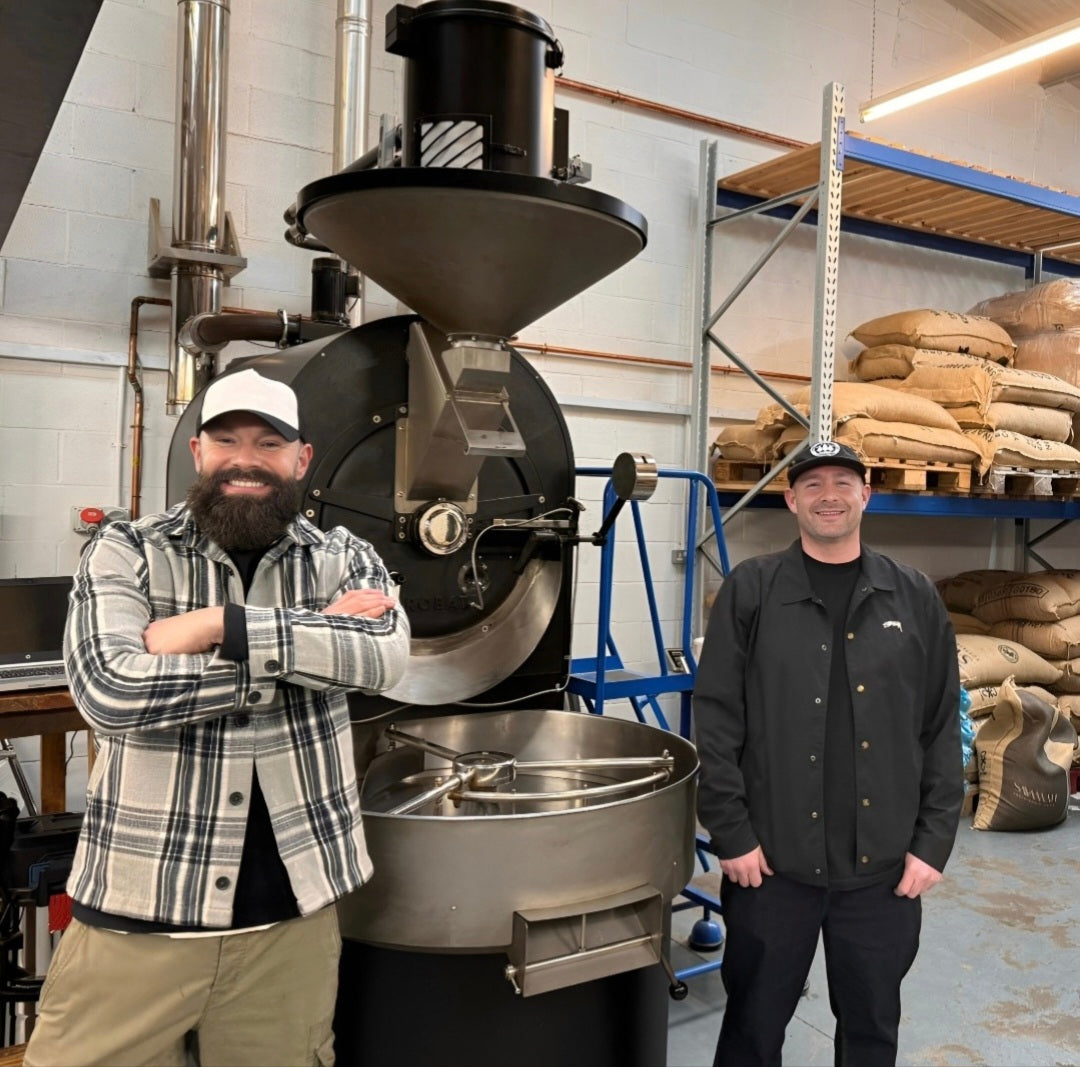 Artisan coffee roastery with staff members in front of roasting equipment