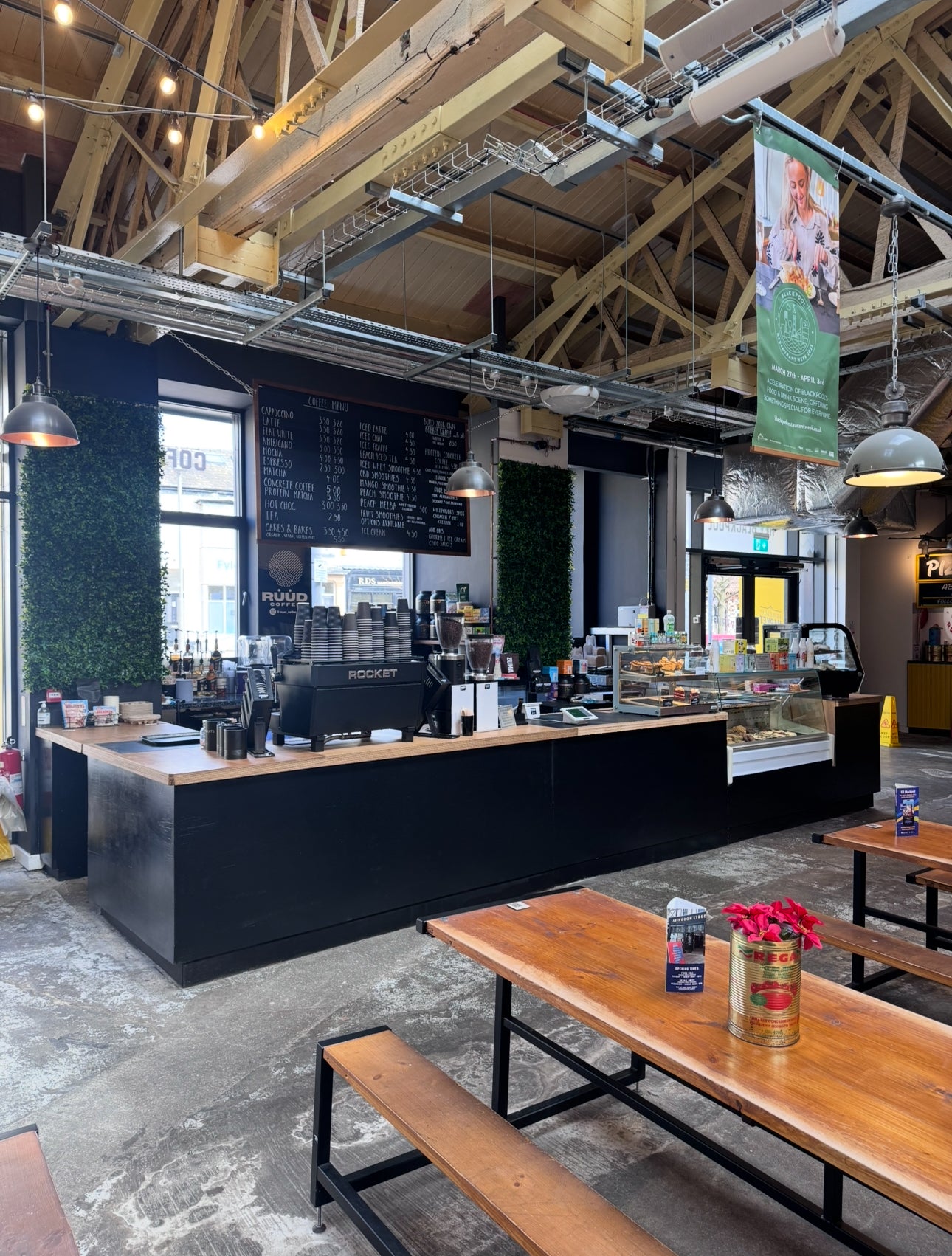 Modern café interior with espresso bar, wooden tables and industrial lighting